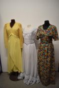 Three vintage late 1960s/70s maxi dresses, including vibrant floral dress with angel sleeves.