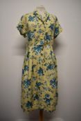 A 1940s St Michael floppy floral cotton day dress, having buttons to front and yellow ground with