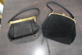 Two vintage black suede handbags, having clasp fastenings.