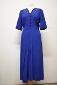 A late 1940s royal blue crepe day dress, having machine embroidery and self covered buttons to