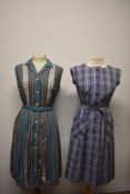 A late 1950s brightly patterned day dress with belt and pleated skirt and a lilac 1960s pinafore