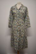 A 1940s floral cotton day dress, having scalloped edges to collar, cuffs and bodice, button down