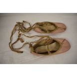 A pair of vintage child's pink leather ballet shoes.