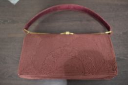 A vintage burgundy cord box bag, having internal compartments and clasp fastening.