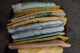 A box of double Damask pastel coloured table cloths and some unused table cloth fabric.