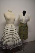 A 1950s fairly full cotton skirt, having pink, blue, grey and black patterns to white ground with
