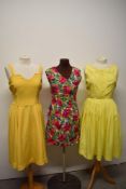 An early 1960s yellow day dress having pleated skirt, a 1960s floral mini dress and a 1950s yellow