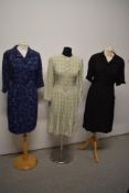 Three 1950s day dresses, comprising; navy blue patterned dress, black textured crepe dress and