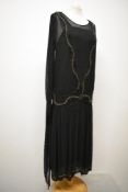 An Art Deco 1920s beaded flapper dress, having integrated slip, 3/4 sleeves ending in a point and