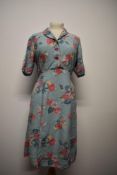 A cheerful 1940s floral cotton day dress, having buttons to front and side metal zip, medium size.