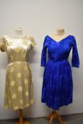 A cream satin 1950s wiggle dress having Oriental type pattern and a 1950s blue texture taffeta dress