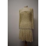 A 1980s does 1920s dress, heavily beaded throughout with long sleeves and dropped waist.