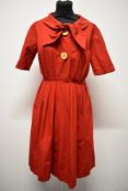 A 1950s medium weight cotton cherry red day dress, having large statement buttons, ties to neck,