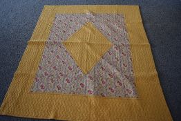 A 1930s/40s 'The Comfy' quilt, having paisley diamond to centre with block yellow surround and