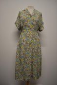 A 1940s cotton day dress, having novelty Lion and Unicorn print on floral ground, buttons to front