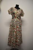 A 1940s gossamer fine silk novelty print day dress, having large collar, self covered buttons, cap