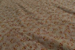 An early 20th century floral quilt with plain hand stitched reverse and machine stitched front,