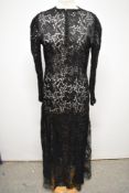 A 1930s bias cut lace evening dress, having button down front, round collar and long sleeves with