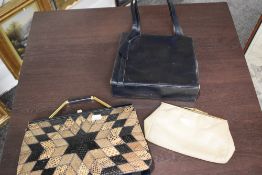 Two vintage famed handbags, having clasp fastenings and a clutch bag.