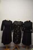 Three 1950s to 1960s black dresses, including elegant early 60s lace dress with satin to skirt.