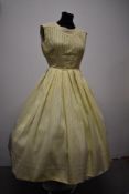 A 1950s full skirted yellow day dress of textyred cotton or cotton blend fabric, with tucks and