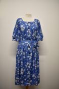 A mid century floppy cotton day dress, having blouson sleeves, button down front and tie belt to
