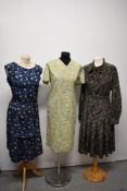 Three vintage 1960s dresses, including yellow floral cotton dress, larger sizes.