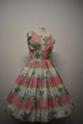 A pretty 1950s cotton day dress, having faux buttons to bodice, pleated skirt and side metal zip.