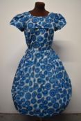 A blue 1950s day dress, having side metal zip, fairly full pleated skirt and bow detail to