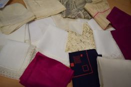 An assortment of handkerchiefs and headscarves, including souvenir scarf, bright silk scarves and