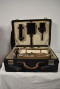 A 1930s/40s vanity travel case, housing a selection of jars and bottles, brushes and mirror etc.