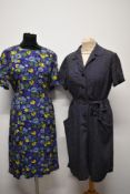 Two 1950s cotton day dresses, one having abstract floral pattern on purple ground and the other navy