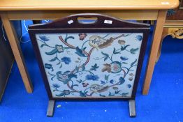 A traditional stained frame fire screen with embroidered insert