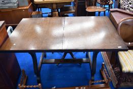A traditional dark stained oak refectory table, having extending mechanism