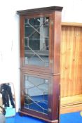 A late 19th/early 20th Century mahogany double height corner display cabinet