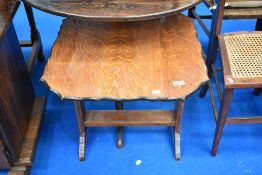 An early 20th Century oak occasional table having tilt top to convert to fire screen