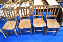 A set of four traditional Elm solid seat chairs, possibly chapel chairs