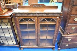 An early 20th Century oak carved 'lees' bookcase