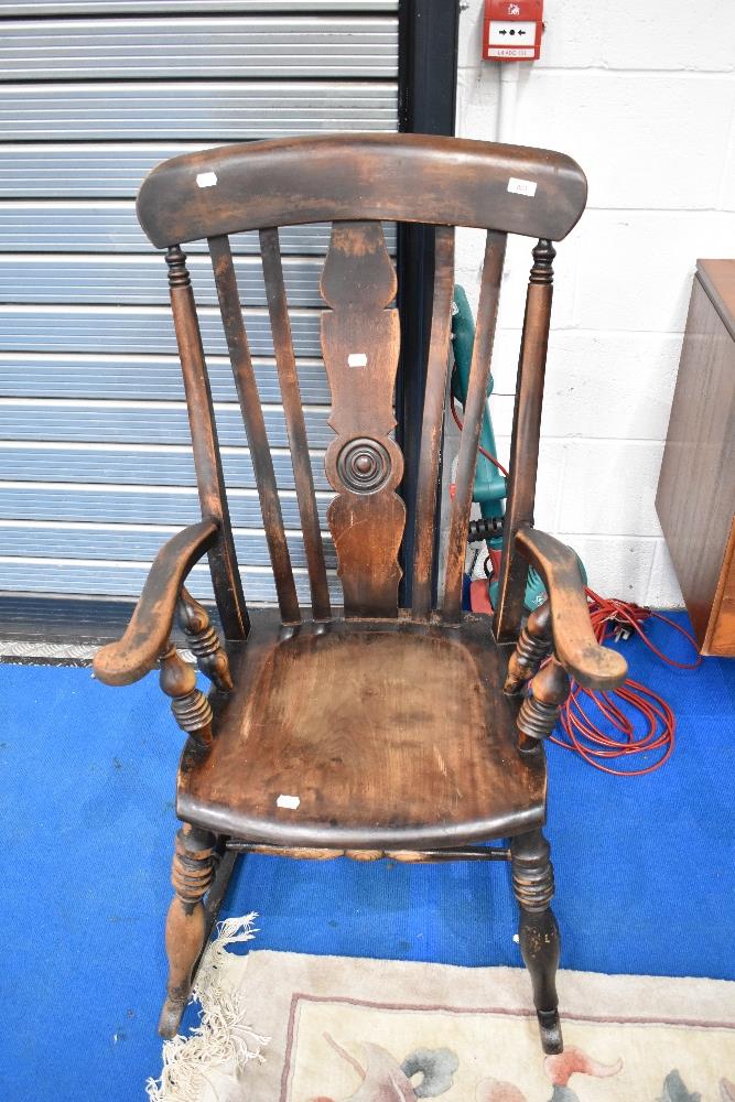A Victorian stained frame solid seat rocking chair having turned frame