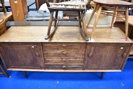 A vintage elm sideboard, probably Ercol having central four drawer section flanked by cupboards on