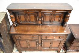 A dark stained Ercol court cupboard