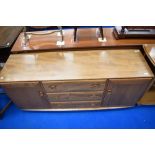 An Ercol sideboard having three central drawers flanked by cupboards