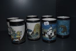 Seven Ambleside pottery mugs, or varying design, including ships, otters, birds etc.