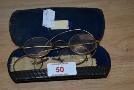 Two pairs of antique gold toned framed spectacles.