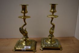 A pair of 19th century intricately embossed brass candlesticks, having Maltese fish to stems.