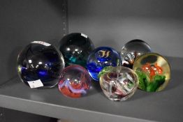 Seven paperweights, including Caithness and Avondale glass.