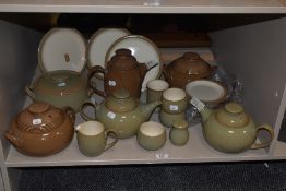 An assortment of Denby, including tureens, tea and coffee pots, plates etc, some in brown glaze