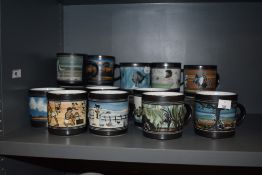 A collection of Ambleside pottery mugs, various designs, including snowman, cave man, dinosaurs,