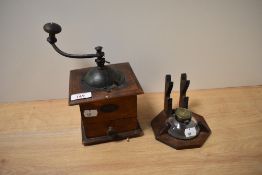 A vintage coffee grinder and a pin stand with glass ink well.