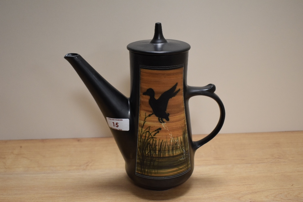 An Ambleside pottery coffee pot, having black ground with flying duck design.